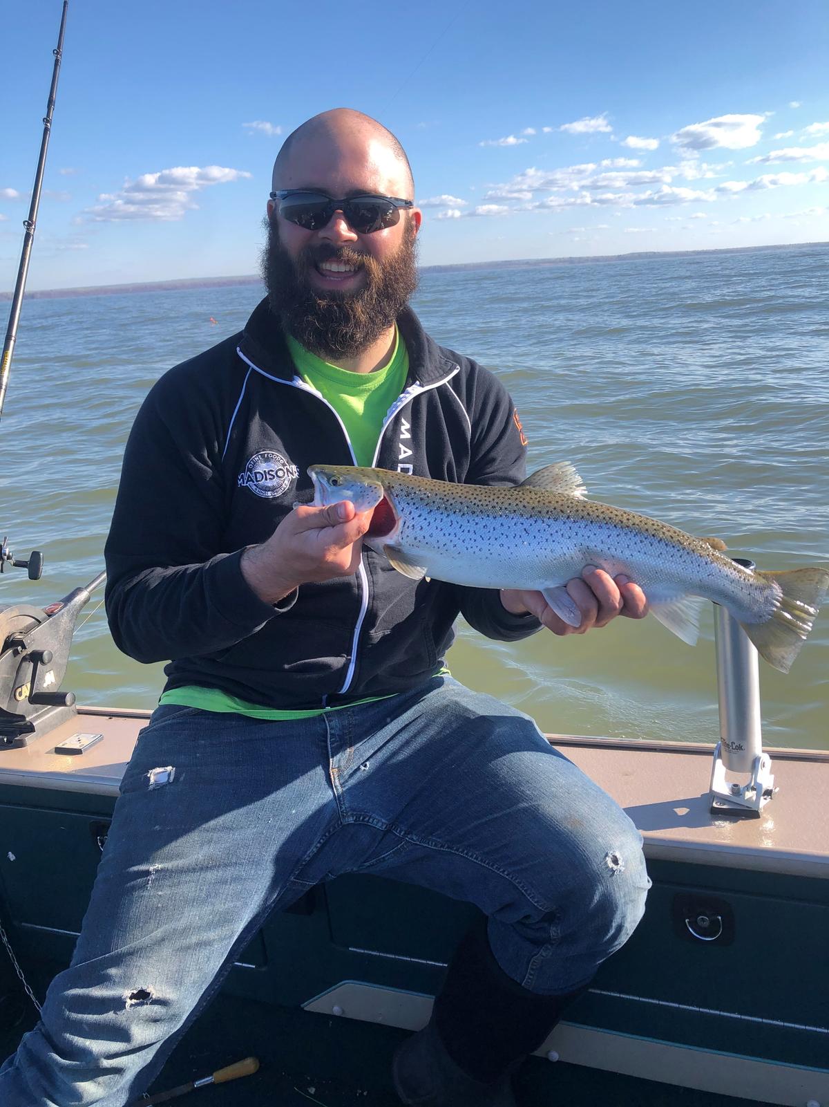 Ryan Lepak on a boat holding a fish.