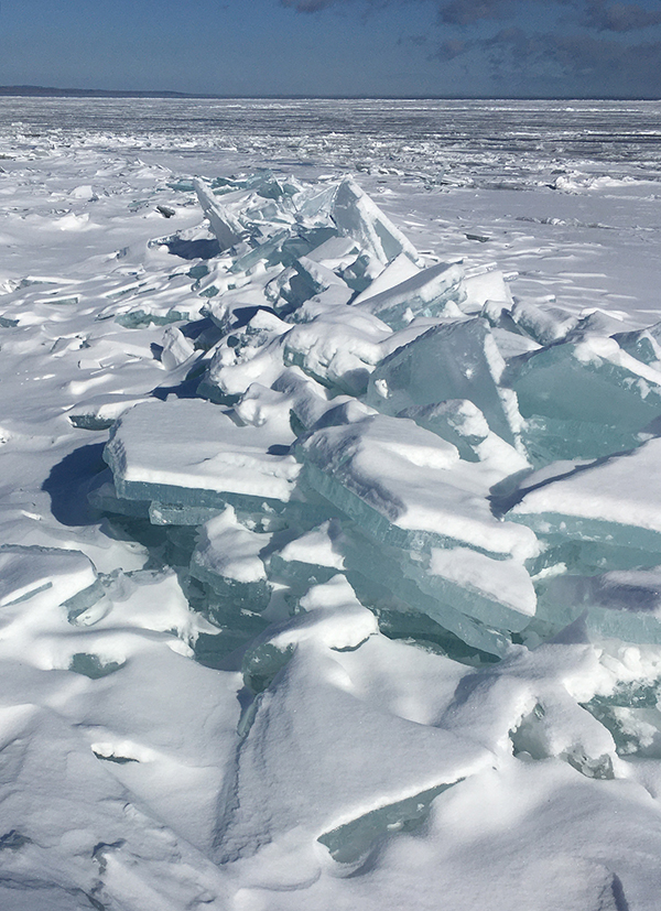 Hummocked ice piled along Lake Superior shoreline.