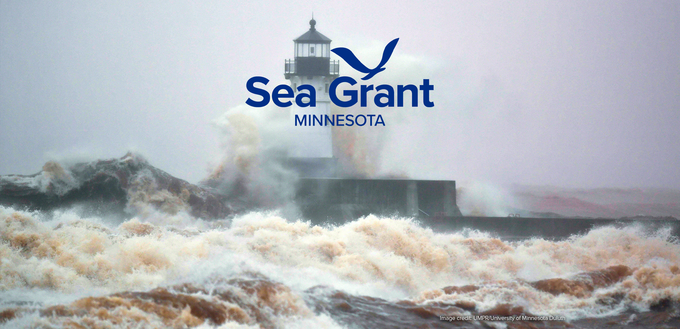 Lake Superior waves engulfing a lighthouse on a pier in Duluth, Minnesota