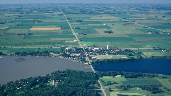 Aerial view of two Minnesota lakes. One with carp and murky water on the left and a lake without car and clearer water on the right.  