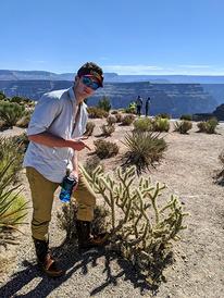 Minnesota Sea Grant Student Worker John Emmer posing next to a cactus in Grand Canyon National Park, Arizona.