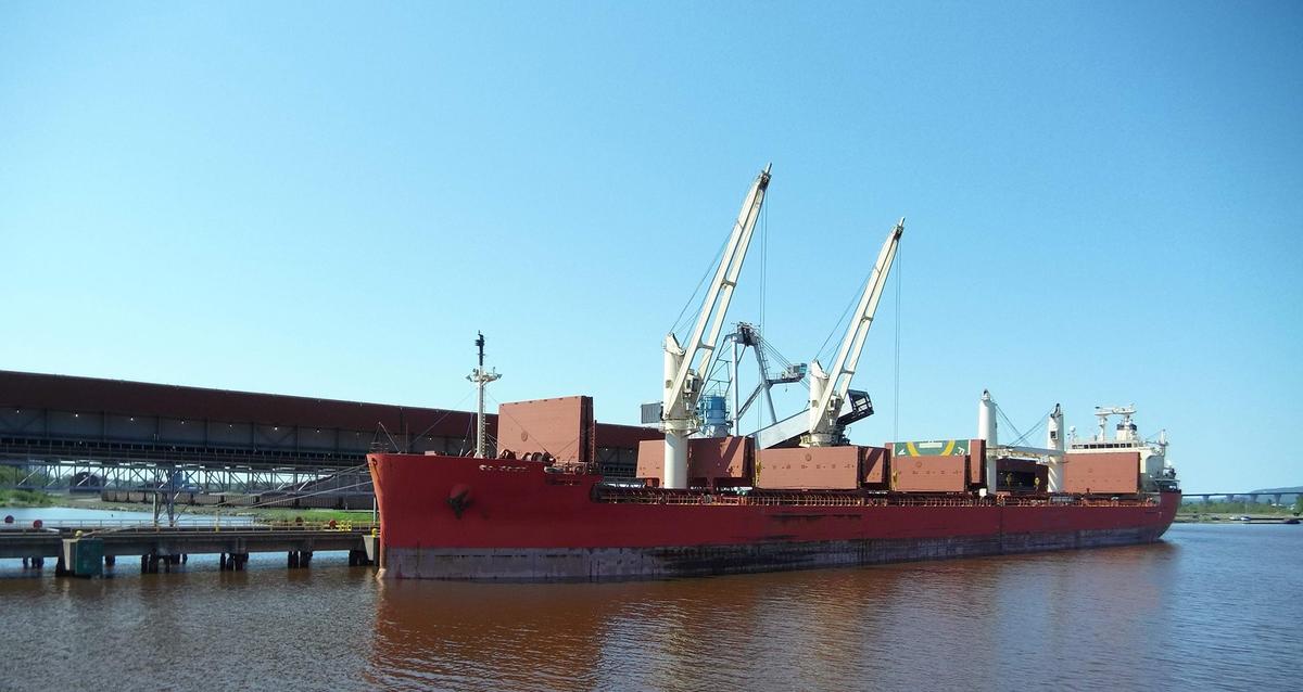A ship docked in the Duluth-Superior Harbor is being loaded or off-loaded by two cranes.