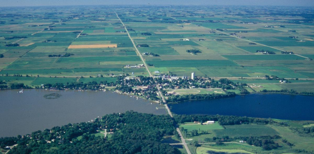 Aerial view of two Minnesota lakes. One with carp and murky water on the left and a lake without car and clearer water on the right.  